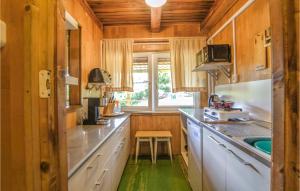 a kitchen with white cabinets and a green floor at Nice Home In Wilimy With Kitchen in Wilimy