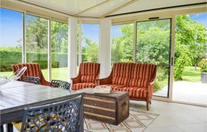 a screened in porch with two chairs and a table at Cozy Home In Saint-Georges in Bourlens