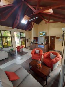 a large living room with red chairs and a table at HOTEL Y RESTAURANTE HACIENDA LOS VOLCANES in Santa Lucía Milpas Altas