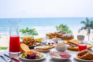 a table with breakfast food on the beach at Peninsula Hotel Danang in Danang