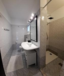 bagno con lavandino e specchio di Apartments Mari a Novigrad Istria