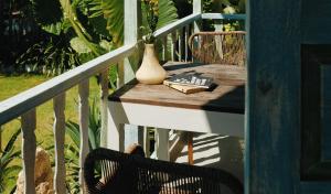 una mesa en un balcón con un jarrón y un libro en Sandy Bay, en Nusa Lembongan