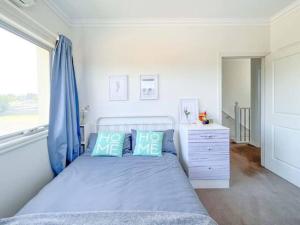 1 dormitorio con 1 cama con cortinas azules y vestidor en Cozy 4B3B home w parking WIFI @Clayton, en Clayton North