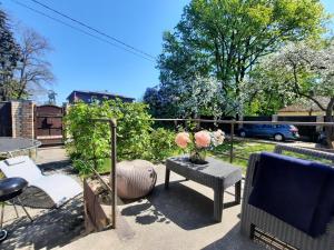un patio con sillas y una mesa con flores. en Cozy private house with a yard & parking, en Riga