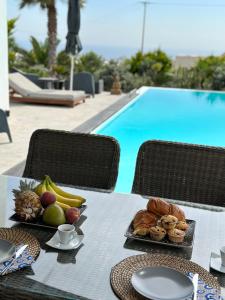 a table with food on it next to a pool at Kaminos Private Villa in Vóthon