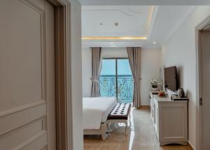 a bedroom with a bed and a view of the ocean at MerPerle Beach Hotel in Nha Trang