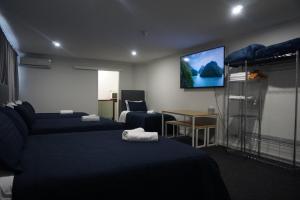 Habitación de hotel con 2 camas y TV de pantalla plana. en Warners Bay Hotel en Warners Bay