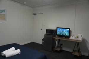 een kamer met een bed en een computer op een bureau bij Warners Bay Hotel in Warners Bay