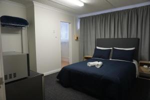 Postel nebo postele na pokoji v ubytování Warners Bay Hotel