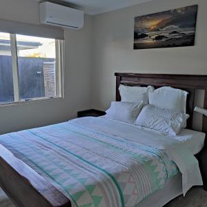 a bedroom with a large bed with a window at Holiday Home in Papamoa in Tauranga
