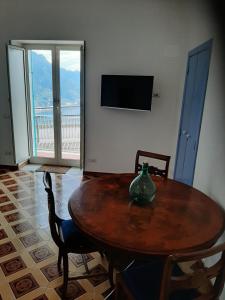a wooden table with chairs and a vase on it at Dan Ravello in Ravello