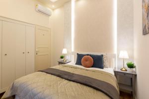1 dormitorio con 1 cama grande con almohadas azules en Luxurious Central Apartment in Liszt Ferenc Square, en Budapest