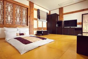 a bedroom with a bed and a television in it at Hanok Stay Namwonyechon by Kensington in Namwon