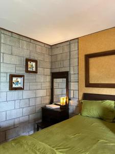 1 dormitorio con cama verde y espejo en Djiwanta Cottage by Balkondes Sambirejo, en Groyokan