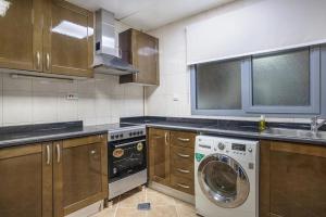 a kitchen with a washing machine and a sink at HUGE 2 Bedroom Apartment Beach Front (City View) in Abu Dhabi +7 photos