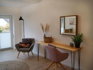 Zimmer mit einem Tisch, einem Stuhl und einem Spiegel in der Unterkunft Ferienwohnung Nr 4 in Litzendorf