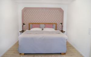 a bedroom with a large bed with two lamps at Ferienwohnung Nr 4 in Litzendorf