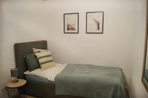 a bedroom with a bed with three pictures on the wall at Ferienwohnung Nr 4 in Litzendorf