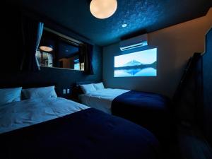 Habitación oscura con 2 camas y TV. en Rakuten STAY VILLA Lake Yamanakako 102 View bath Mt Fuji View en Yamanakako