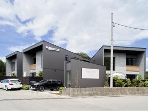 een zwart gebouw met een auto ervoor geparkeerd bij Rakuten STAY VILLA Lake Yamanakako 102 View bath Mt Fuji View in Yamanakako