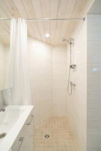 a white bathroom with a shower and a sink at Posti studio apartment in Paide