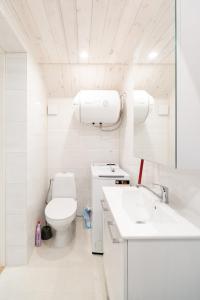 a white bathroom with a toilet and a sink at Posti studio apartment in Paide