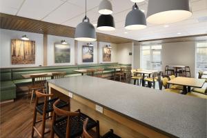 a restaurant with a bar and tables and chairs at Fairfield Inn & Suites Raleigh Durham Airport Research Triangle Park in Morrisville