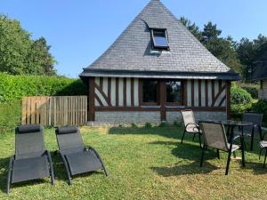 a group of chairs and a table in front of a gazebo at Bener'Inn Au calme Une maison 3 chambres 125 m2 ou Une maison 2 chambres 50 m2 ou les 2 maisons in Bénerville-sur-Mer