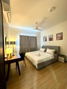 a bedroom with a bed and a table and a desk at Modern Stylish Apartment (Seaview) near KTCC Mall. in Kuala Terengganu