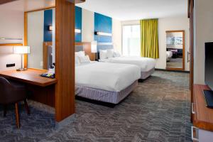 a hotel room with two beds and a desk and a television at SpringHill Suites by Marriott Kansas City Lenexa/City Center in Lenexa