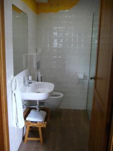 y baño blanco con lavabo y ducha. en Apartamentos Rurales Casa Lafuente, en Luquiano