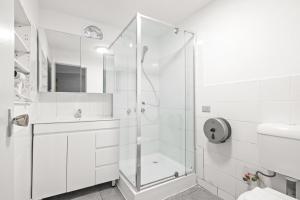 a white bathroom with a shower and a sink at Signature Double Room in Auburn in Sydney