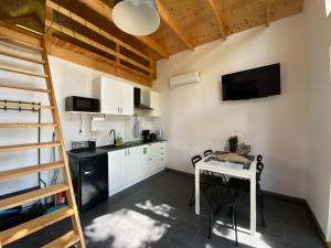 a kitchen with a table and a small kitchen with a ladder at Physio House Sokolik in Komarno