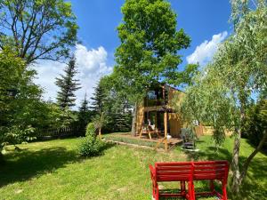 a red bench in the yard of a house at Physio House Sokolik in Komarno
