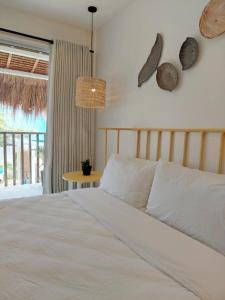 a bedroom with a bed and a table and a window at Sea Green Boutique Rooms in General Luna