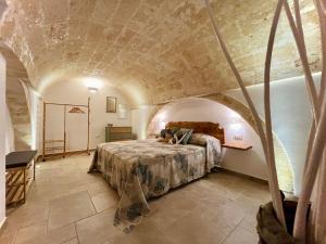 a bedroom with a bed in a room with a stone wall at Antica Dimora "Lu suli, Lu mari, Lu jentu" in Monacizzo