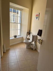 a bathroom with a toilet and a window at 7A Murray Street in Duns