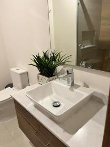 a white bathroom with a sink and a toilet at Camino al Mar in Mazatlán +9 photos
