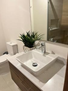 a white bathroom with a sink and a toilet at Camino al Mar in Mazatlán