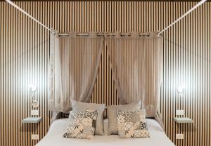 - une chambre avec un lit doté de rideaux et d'oreillers dans l'établissement Holiday Eolie Village, à Vulcano