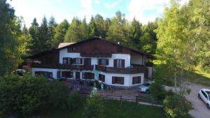 a large white house in the middle of a forest at Albergo Scoiattolo in Tret