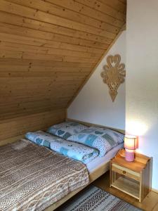 a bed in a room with a wooden ceiling at Zamajerz Nad Zalewem in Niedzica Zamek