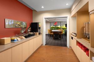 a kitchen with red walls and a dining room at TownePlace Suites San Jose Santa Clara in Santa Clara