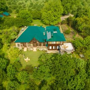 Ramgarh Heritage Villa, Manali, amã Stays & Trails في مانالي: إطلالة علوية على منزل كبير بسقف أخضر
