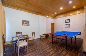 Ramgarh Heritage Villa, Manali, amã Stays & Trails في مانالي: غرفة تنس طاولة وكراسي تنس طاولة
