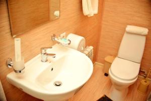 a bathroom with a white sink and a toilet at Sapar Budget Hotel in Shymkent