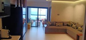 a living room with a couch with pillows on it at résidence Copacabana mehdia in Kenitra