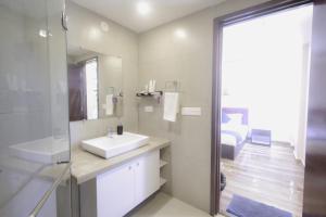 a bathroom with a white sink and a shower at Eternal wave by HappyInch in Calangute