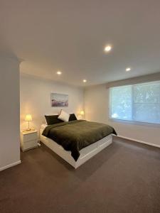 Un dormitorio con una cama grande y una ventana en Dee Why Town House, en Deewhy