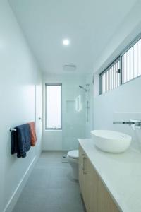een witte badkamer met een wastafel en een toilet bij Margaret River Coastal Apartments in Prevelly